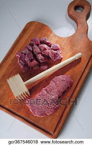 Close-up of meat cubes with a meat tenderizer View Large Photo Image Stock Photo - Close-up of meat cubes with a meat tenderizer. Fotosearch