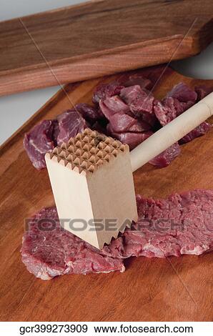 Close-up of meat cubes with a meat tenderizer View Large Photo Image Stock Photo - Close-up of meat cubes with a meat tenderizer. Fotosearch
