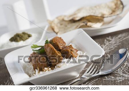 Close-up of mutton curry served with rice and papadums View Large Photo Image Stock Photo - Close-up of mutton curry served with rice and papadums. Fotosearch