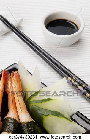 Stock Image - Close-up of nigiri sushi served with soy sauce. Fotosearch