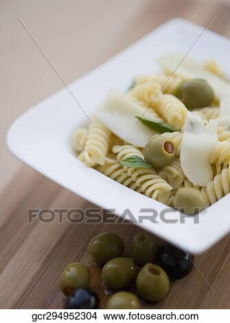 Picture - Close-up of pasta in a bowl with olives. Fotosearch