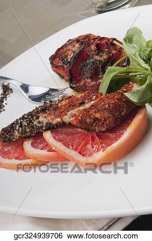 Stock Photograph - Close-up of pepper coated chops with grapefruit. Fotosearch
