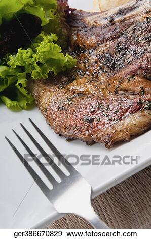 Close-up of pork chops served with lettuce View Large Photo Image Stock Photo - Close-up of pork chops served with lettuce. Fotosearch