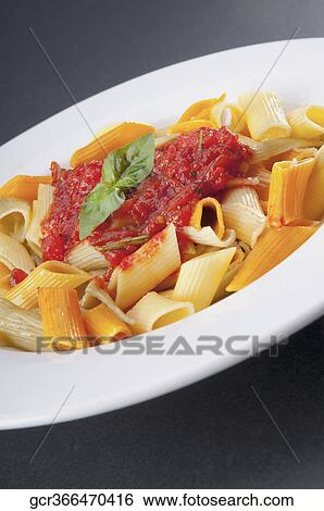 Stock Photograph - Close-up of rigatoni pasta topped with tomato concasse. Fotosearch