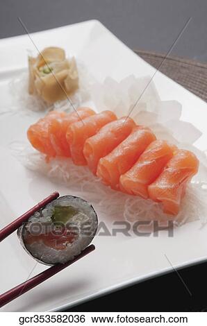 Close-up of salmon rolls with chopsticks View Large Photo Image Stock Photograph - Close-up of salmon rolls with chopsticks. Fotosearch