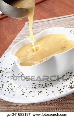Stock Photo - Close-up of soup being poured into a bowl. Fotosearch