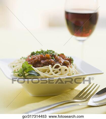 Stock Image - Close-up of spaghetti and meat with red wine. Fotosearch