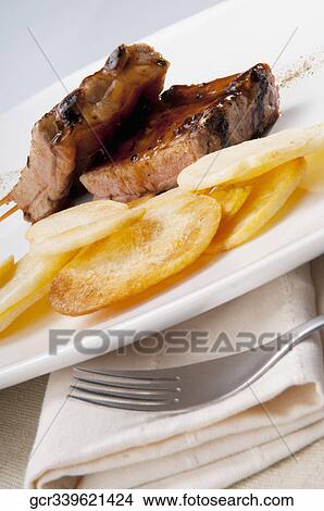 Close-up of spare ribs and chips View Large Photo Image Picture - Close-up of spare ribs and chips. Fotosearch