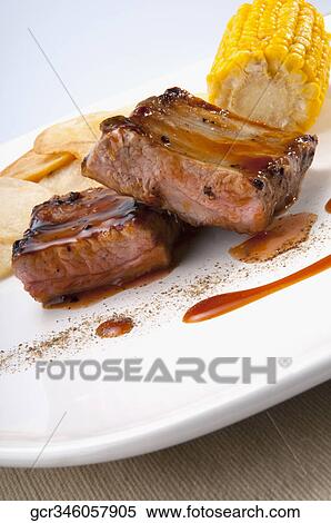 Close-up of spare ribs served with corn on the cob View Large Photo Image Stock Photography - Close-up of spare ribs served with corn on the cob. Fotosearch