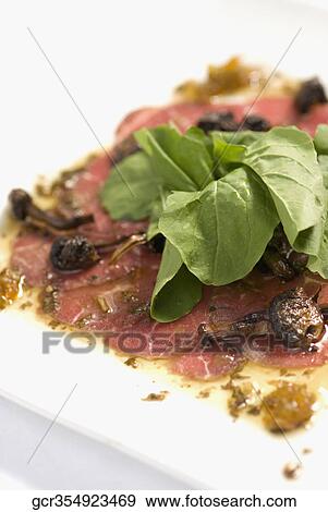 Stock Photo - Close-up of spinach topped on pepperoni. Fotosearch