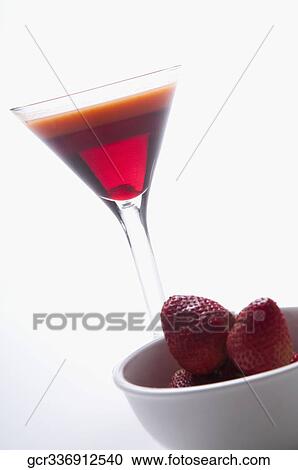 Stock Image - Close-up of strawberries with a glass of cocktail. Fotosearch
