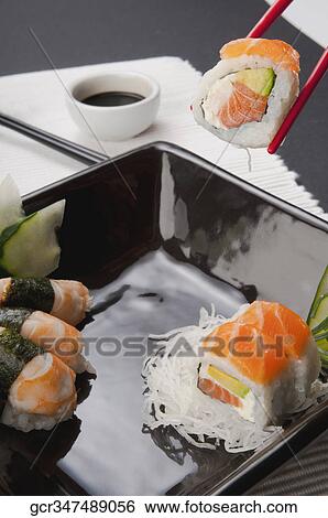 Close-up of sushi with chopsticks and soy sauce View Large Photo Image Stock Photograph - Close-up of sushi with chopsticks and soy sauce. Fotosearch