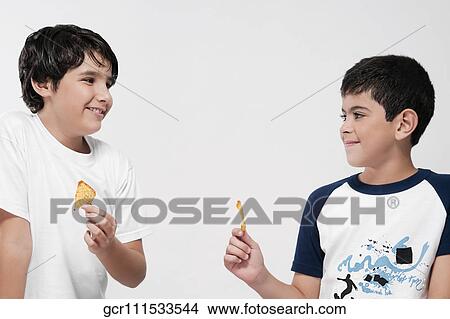 Picture - Close-up of two boys eating nachos. Fotosearch
