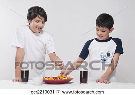 Close-up of two boys sharing a platter of nachos View Large Photo Image Stock Photo - Close-up of two boys sharing a platter of nachos. Fotosearch