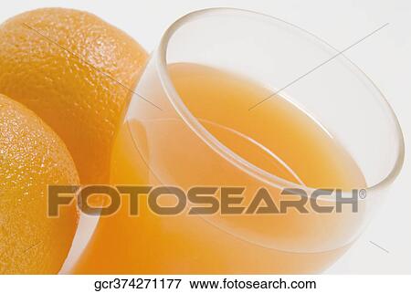 Close-up of two oranges with a glass of orange juice View Large Photo Image Stock Photo - Close-up of two oranges with a glass of orange juice. Fotosearch