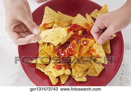 Close-up of two people's hands picking nachos from a platter View Large Photo Image Stock Image - Close-up of two people's hands picking nachos from a platter. Fotosearch