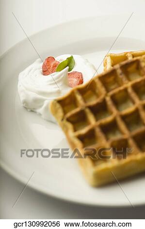 Close-up of waffles and cream on a plate View Large Photo Image Stock Photograph - Close-up of waffles and cream on a plate. Fotosearch