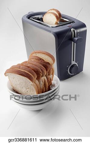 Stock Image - Close-up of white breads in a bowl with a toaster. Fotosearch