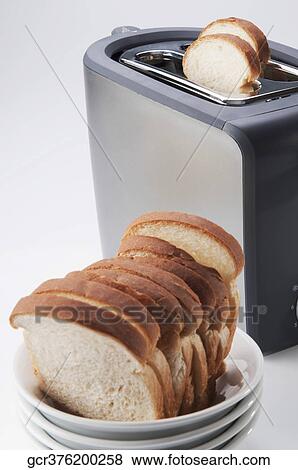 Stock Photo - Close-up of white breads in a bowl with a toaster. Fotosearch