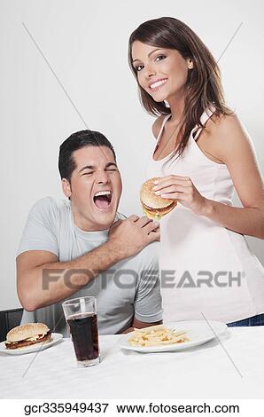 Couple eating hamburgers View Large Photo Image Stock Photo - Couple eating hamburgers. Fotosearch