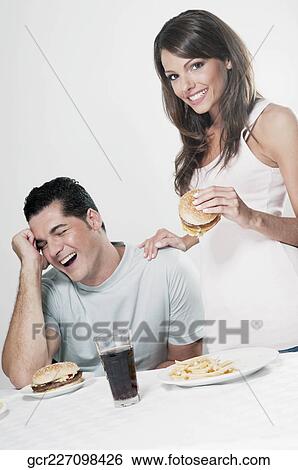 Couple eating hamburgers View Large Photo Image Stock Photograph - Couple eating hamburgers. Fotosearch