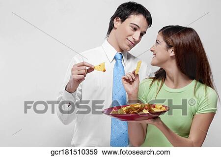 Couple eating nachos View Large Photo Image Stock Photo - Couple eating nachos. Fotosearch