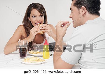 Picture - Couple enjoying snacks together. Fotosearch