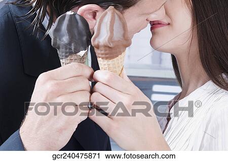 Couple holding ice cream and kissing each other View Large Photo Image Stock Image - Couple holding ice cream and kissing each other. Fotosearch