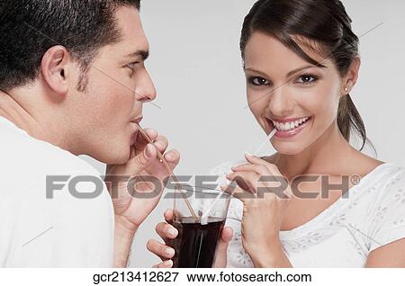 Couple sharing a cola beverage View Large Photo Image Stock Photo - Couple sharing a cola beverage. Fotosearch