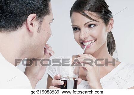 Couple sharing a cola beverage View Large Photo Image Stock Photo - Couple sharing a cola beverage. Fotosearch