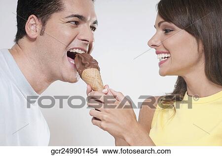 Couple sharing an ice cream cone View Large Photo Image Picture - Couple sharing an ice cream cone . Fotosearch