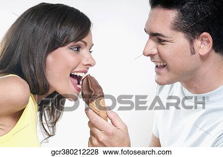 Couple sharing an ice cream cone View Large Photo Image Stock Photo - Couple sharing an ice cream cone. Fotosearch