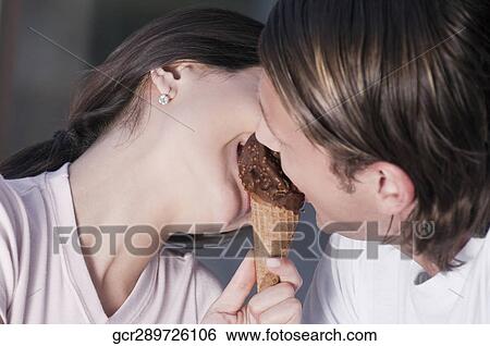 Couple sharing an ice cream View Large Photo Image Stock Photograph - Couple sharing an ice cream. Fotosearch