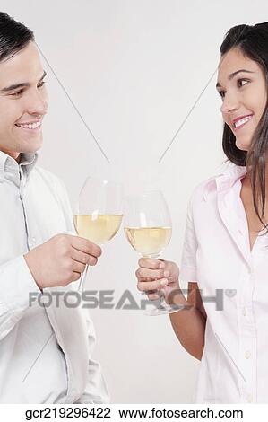 Couple toasting glasses of wine and smiling View Large Photo Image Stock Image - Couple toasting glasses of wine and smiling. Fotosearch