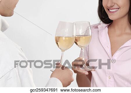 Couple toasting glasses of wine and smiling View Large Photo Image Stock Image - Couple toasting glasses of wine and smiling. Fotosearch