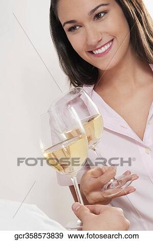 Couple toasting glasses of wine and smiling View Large Photo Image Stock Photo - Couple toasting glasses of wine and smiling. Fotosearch
