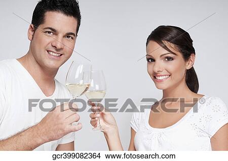 Couple toasting with white wine glasses View Large Photo Image Picture - Couple toasting with white wine glasses. Fotosearch