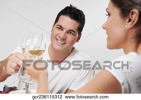 Couple toasting with white wine glasses View Large Photo Image Stock Image - Couple toasting with white wine glasses. Fotosearch