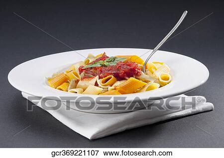 Stock Photo - Dish of rigatoni pasta topped with tomato concasse. Fotosearch