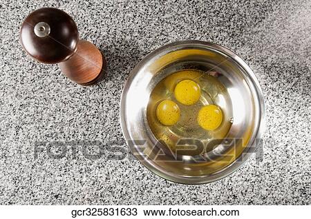Egg yolk in a bowl next to a pepper mill View Large Photo Image Stock Image - Egg yolk in a bowl next to a pepper mill. Fotosearch