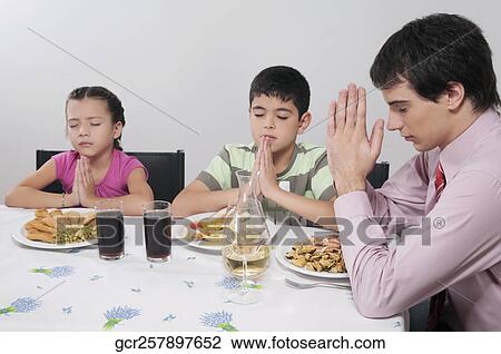 Family praying before lunch View Large Photo Image Stock Image - Family praying before lunch. Fotosearch