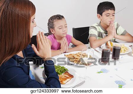 Stock Photo - Family praying before lunch. Fotosearch