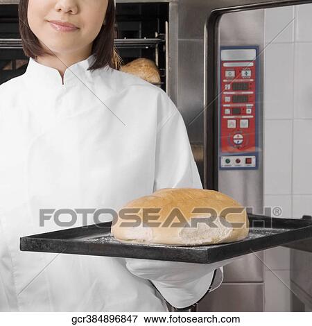 Female chef holding a bun in a tray View Large Photo Image Stock Photo - Female chef holding a bun in a tray. Fotosearch