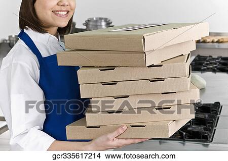 Female chef holding stack of pizza boxes and smiling View Large Photo Image Picture - Female chef holding stack of pizza boxes and smiling. Fotosearch