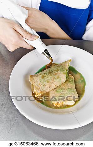 Stock Photograph - Female chef icing pastries. Fotosearch