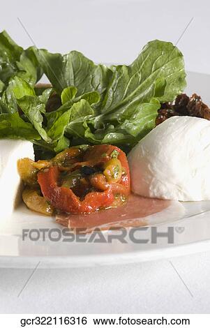 Feta cheese served with lettuce and tomatoes on a plate View Large Photo Image Stock Photograph - Feta cheese served with lettuce and tomatoes on a plate. Fotosearch