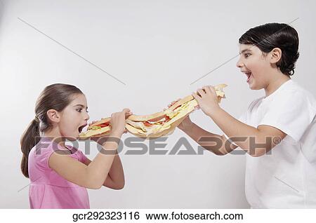Girl and boy eating a submarine sandwich View Large Photo Image Stock Photograph - Girl and boy eating a submarine sandwich. Fotosearch