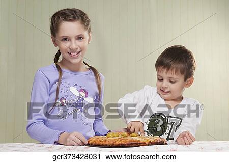 Girl and her brother eating a pizza View Large Photo Image Stock Image - Girl and her brother eating a pizza. Fotosearch