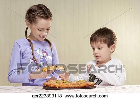 Stock Photo - Girl and her brother eating a pizza. Fotosearch