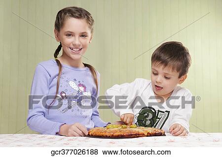 Stock Photo - Girl and her brother eating a pizza. Fotosearch